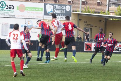 Mourad i Sans, de la UE Tàrrega, pugnen per arribar a una pilota aèria amb Mestres, del Linyola, durant una acció del partit.