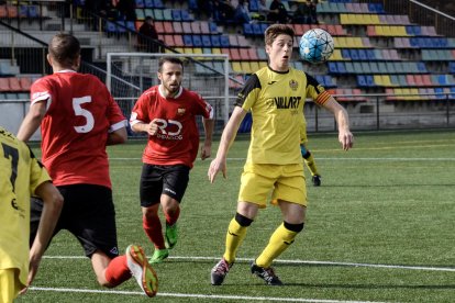 El capità del Balaguer i autor de l’únic gol d’ahir, Isaac, controla la pilota amb el pit davant de la pressió de dos jugadors del Santboià.