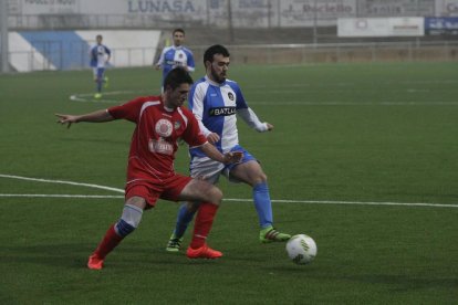 Un jugador del Tamarit y uno del Binéfar disputan un balón.