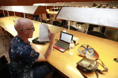 Un usuari de la sala, ahir a la tarda, ventant-se amb un full de paper per combatre la calor.