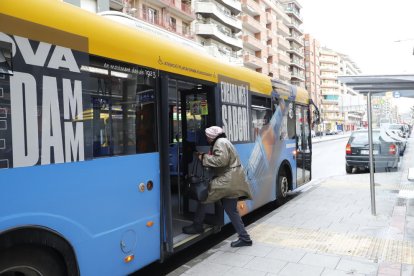 Una dona puja a un autobús per la porta posterior, ahir.