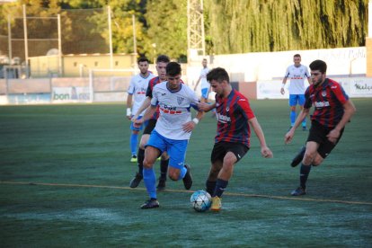 Una pugna entre dos futbolistas, ayer durante el partido en el Municipal de Mollerussa.