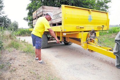 Un agricultor assenyala els clots que provoquen danys a la fruita que transporta.