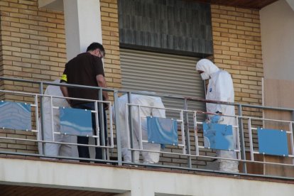 Mossos inspeccionando el balcón desde el que la hija del fallecido pidió auxilio. 