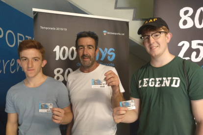 Tres abonados del Lleida Esportiu muestran orgullosos ayer su carnet.