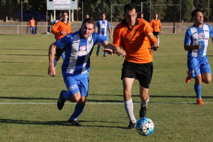 Un jugador del Torregrossa pugna per la pilota amb el capità de la Seu.