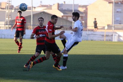 Jugadors dels dos conjunts pugnen per una pilota aèria.