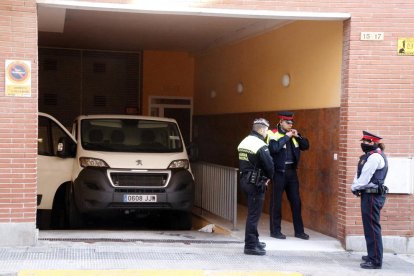 El vehicle de la funerària es disposa a treure el cos de la dona davant de la vigilància dels Mossos.