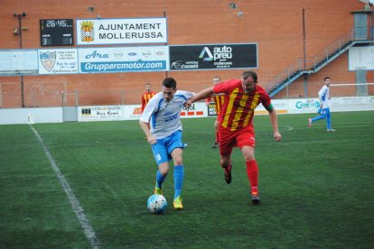 El jugador del Mollerussa, Fontana, trata de escaparse de la defensa de un oponente cerca de la línea de medio campo.