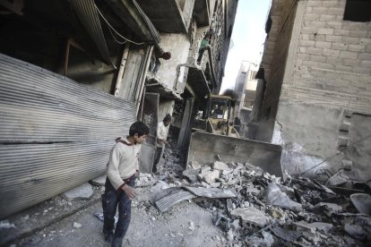 Varios niños juegan entre las ruinas causadas por los bombardeos.