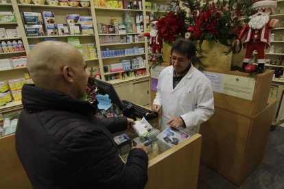 Un client comprant un medicament dissabte en una farmàcia de Ferran.