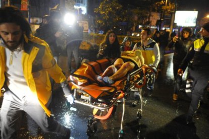 Els serveis mèdics traslladen en llitera a una ambulància un ferit en l’atac contra el popular club nocturn Reina, a Istanbul.