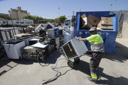 Un operario de la actual ‘deixalleria’, junto a las instalaciones de Ilnet, recogiendo electrodomésticos.