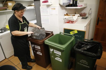 Un negoci de l’Eix Comercial, amb els contenidors de diferents fraccions de residus.