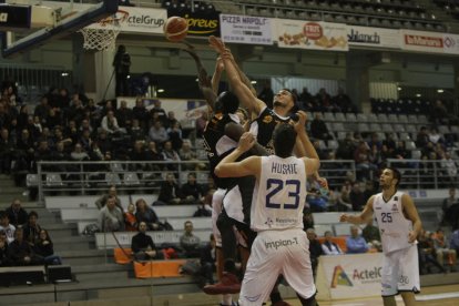 Léo Demétrio i Ablaye Mbaye intenten capturar un rebot davant del potent joc interior del Burgos, format per Javi Vega i Goran Huskic.