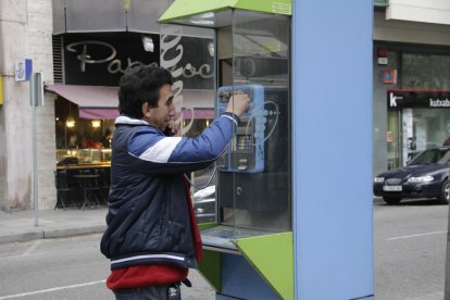 Un usuario en una cabina telefónica ubicada en la Rambla Ferran.