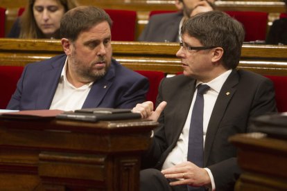 El president de la Generalitat, Carles Puigdemont, conversa amb el vicepresident i conseller d'Economia, Oriol Junqueras.