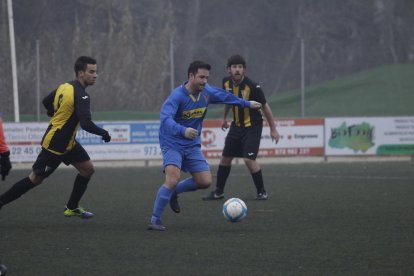 Un jugador del Sudanell controla la pilota davant la pressió de dos adversaris.