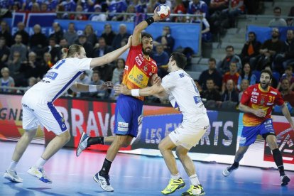 El central espanyol Daniel Sarmiento intenta llançar entre dos jugadors islandesos.