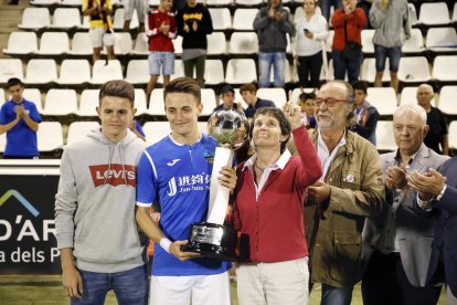 Toni y Joan Vicente, los hijos de Emili, posan junto a su madre, Antònia Armengol, que entregó el trofeo de campeón a Joan, como capitan del Lleida.