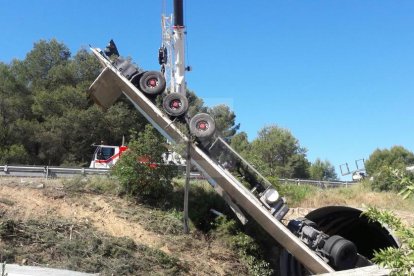 Los trabajos de retirada del camión accidentado en la C-12 en Maials, en el que ha muerto el chófer.