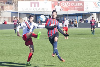 Un jugador de la UE Tàrrega intenta llevarse un balón ante la oposición de un adversario.