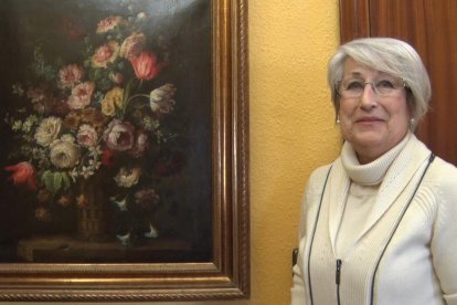 Rosa M. Martorell, de Cervera, al costat del quadre que ha recuperat del seu pare, Josep Martorell.