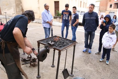 Visitants observen el treball d’un forjador en una mostra que va reunir més de trenta oficis.