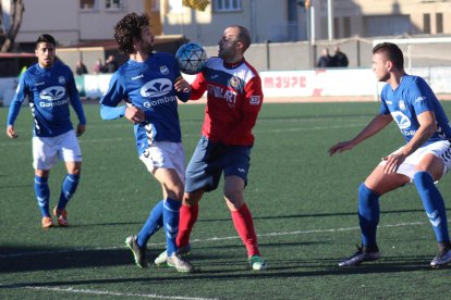 El local Adrià pugna por el balón con un contrario en el centro del campo.