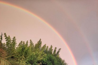 Arc de Sant Martí reflexat en les gotes de pluja sota la llum de la posta de sol . Lleida