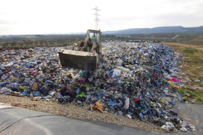 Una de las máquinas distribuyendo ayer la basura por el vaso del vertedero de Les Garrigues. 