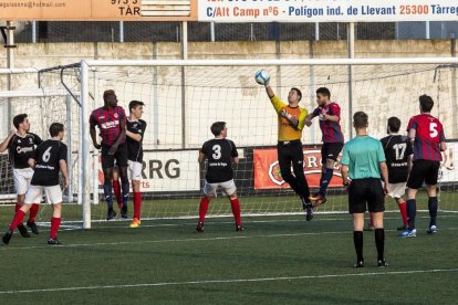 El guardameta visitante, Porta, despeja un balón aéreo ante la proximidad de un jugador rival.