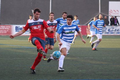 Joan intenta controlar un balón ante la oposición de un jugador del Suburense.