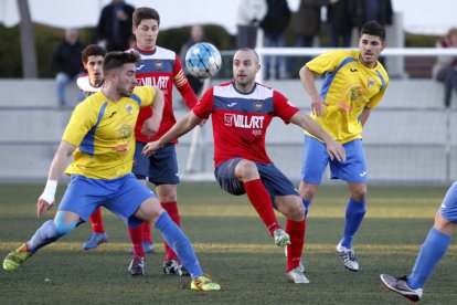 Adrià intenta controlar un balón ante la presencia de un jugador del Vila-seca.