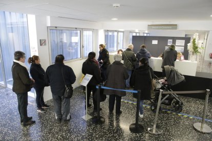 Pacientes esperando ante el mostrador de programación de visitas en un CAP.