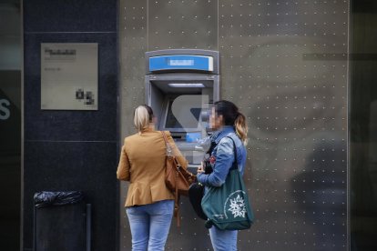 Ciutadanes en un caixer de Lleida ciutat a primera hora del matí.