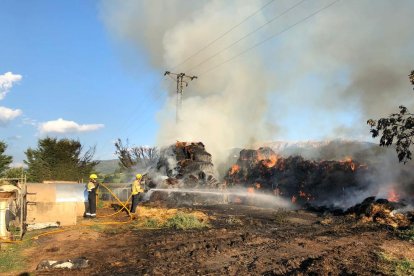 Bombers treballant al costat de la palla en flames.