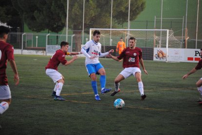 Un jugador del Mollerussa pasa el balón tras la presión del rival.