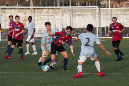 Un jugador del Tàrrega tratando de eludir la defensa de dos rivales.