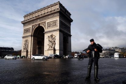 Un policia fa guàrdia davant l’Arc del Triomf, monument que va registrar danys durant els disturbis.