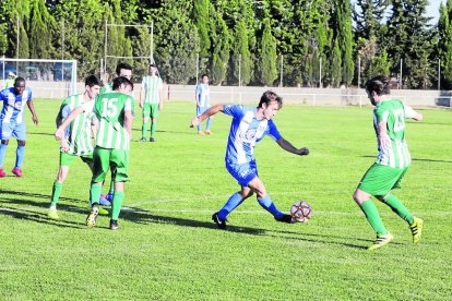 Un jugador del Torregrossa porta la pilota davant de la presència de diversos rivals, ahir durant el partit.