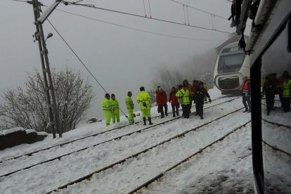 Operaris i efectius que van participar en el ‘rescat’ de passatgers, i el tren Alvia aturat al fons.