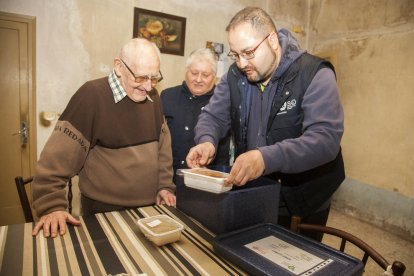 Miquel Àngel i Francisca de Alba entregant el menjar a Josep de 86 anys i que viu sol.