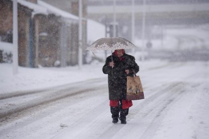 Una dona camina sota la neu per la localitat càntabra de Bolmir.