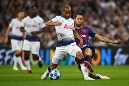 Sergio Busquets intenta arrebatarle el balón al brasileño del Tottenham Lucas Moura.