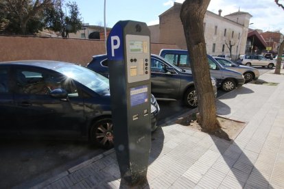 Un carrer amb places d’aparcament regulades per parquímetre.