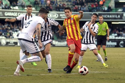 Juanto Ortuño controla la pilota pressionat per diversos futbolistes del Castelló, ahir durant el partit a Castalia.