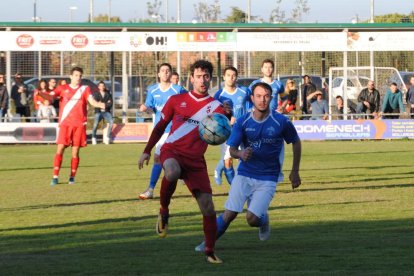 Un jugador de l’Artesa intenta controlar la pilota davant la pressió rival.