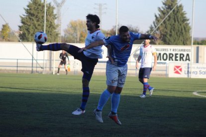 Un jugador del Binèfar, en una disputa de la pilota amb un jugador rival.