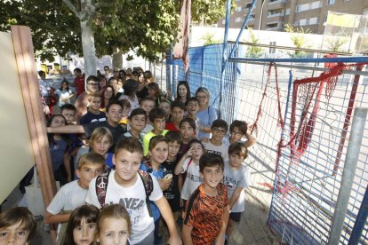 Pares i alumnes del Tonucci, al costat de la pista poliesportiva precintada.